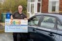Specialist driving instructor Graham Evans with his Made In Bury giant cheque