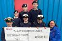 Sub-lieutenant Longley of the Sea Cadets (front left) receives a cheque from Tesco Bury Community Champion Wendy Howarth (front right).