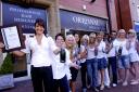 Owner Sandra Kotecha, left, and staff at Originals Hair Studio toast their success