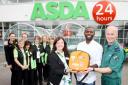 Fabrice Muamba, centre front, with Christine Baldwin, community life champion, left, and Steve Nicholls, HCPC paramedic for the North West Ambulance Service and Asda Bolton colleagues