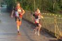 Ethan Statham sprinting to the parkrun finish line alongside pacemaker Rob Fowler
