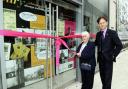 MEMORIES ARE MADE OF THIS: Flo Leeming cuts the ribbon outside the heritage project shop, watched by David Laycock