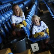 Bury FC fans Ella and Millie Smith help clean up the stadium.