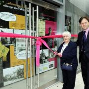 MEMORIES ARE MADE OF THIS: Flo Leeming cuts the ribbon outside the heritage project shop, watched by David Laycock