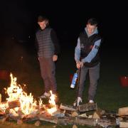 Liam and Connor lighting the fire walk at Woodbank Cricket Club