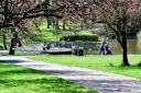 People enjoy the warm weather in Queens Park, Bolton.