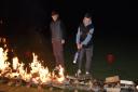 Liam and Connor lighting the fire walk at Woodbank Cricket Club