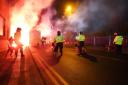 Police officers with dogs as flares are set off outside Villa Park (David davies/PA)