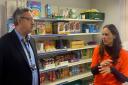 Trust House centre manager Katie Jenkinson showing Cllr Richard Gold around the food pantry