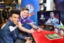 Bolton Wanderers' Derik Osede and Bolton fan Ryan Abbey....Bolton Wanderers' Tony Kelly and Derik Osede launch FIFA 18 at Game, Bolton.