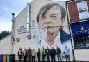 Prestwich Arts Festival volunteers gather at the mural for Mark E Smith