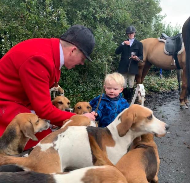 Bury Times: Huntsman Mark Dickson-Bradley introduces Jamie Gallagher, aged 2, to the hounds