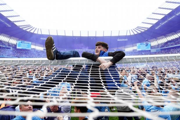 Manchester City fans invade the pitch after their side won the Premier League title