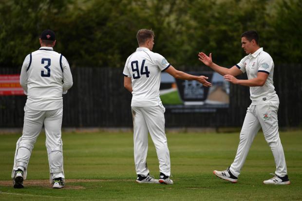HOWZAT: Woodbank bowler Matt Wilkes is congratulated after taking a wicket at Heyside. Picture by Eddie Garvey