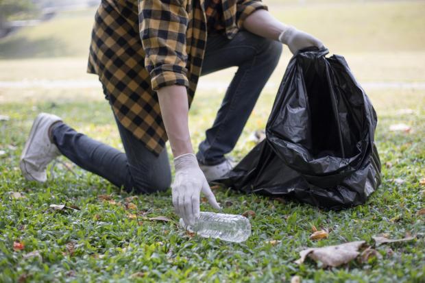 Bury Times: A person picking up litter (Canva)