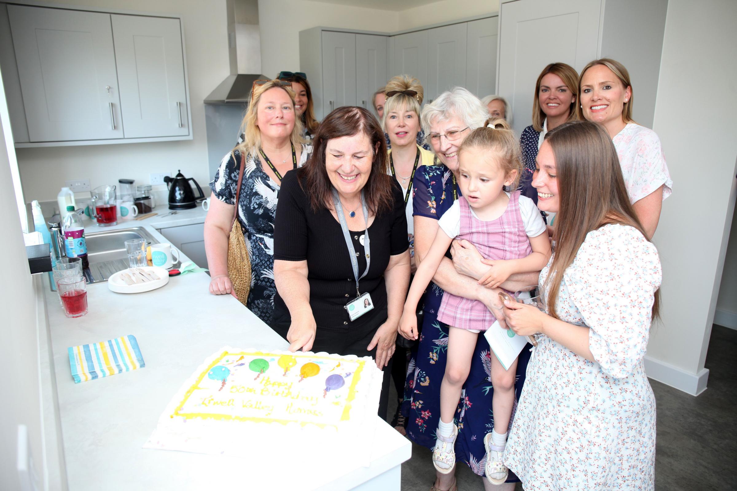 Guests at the launch of Morris Street, Bury, enjoy a birthday cake celebrating 50 years of Irwell Valley Homes