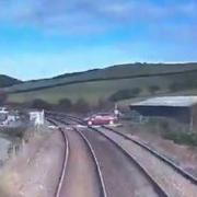 Watch the terrifying moment driver nearly collides with train at level crossing