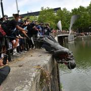 Protesters throw statue of Edward Colston into Bristol harbour during a Black Lives Matter protest rally