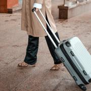 A person pulling a suitcase (Canva)
