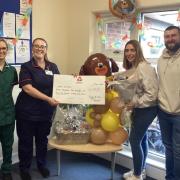 Noah's parents Alex and Mike Williams receive the money from the nursery after its charity week