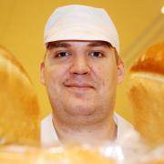 Morrisons baker Paul Smith with some of the fresh loaves donated to the Salvation Army in Bury