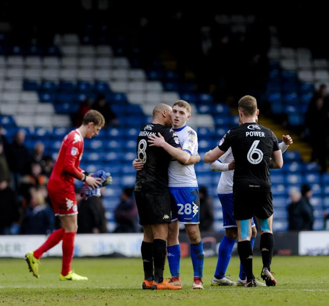 COONEY GLOOM: Bury midfielder Ryan Cooney is consoled by ex-Shaker James Vaughan at the end of Saturday's defeat at Gigg Lane. Picture by Andy Whitehead